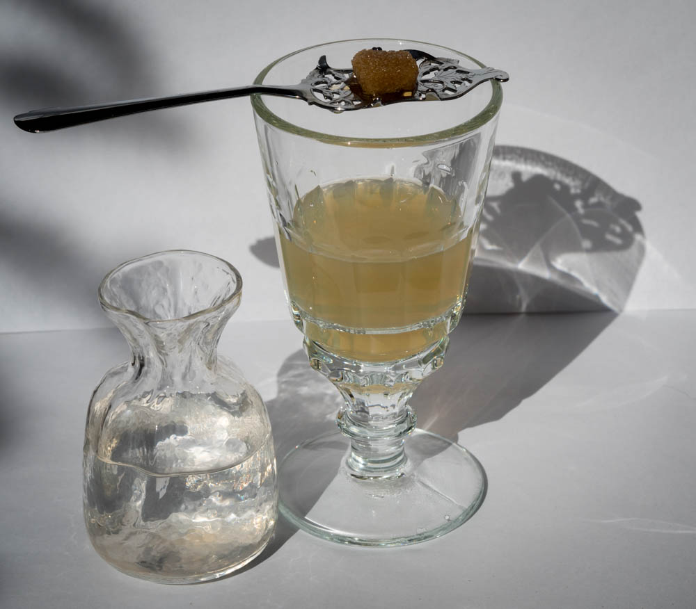 Sweetening absinthe with sugar.